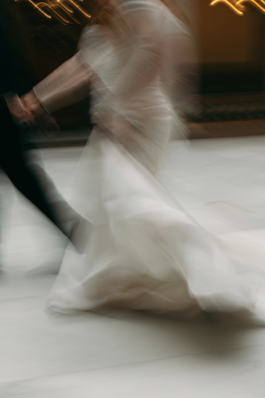 A motion-blur wedding image of a couple running together