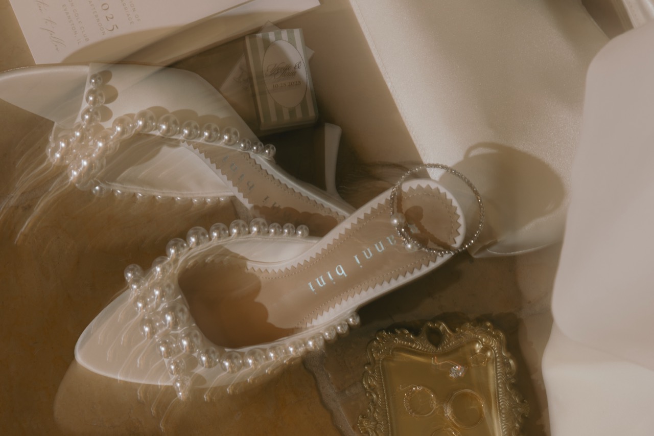 Pearl wedding shoes and rings photographed with soft motion blur