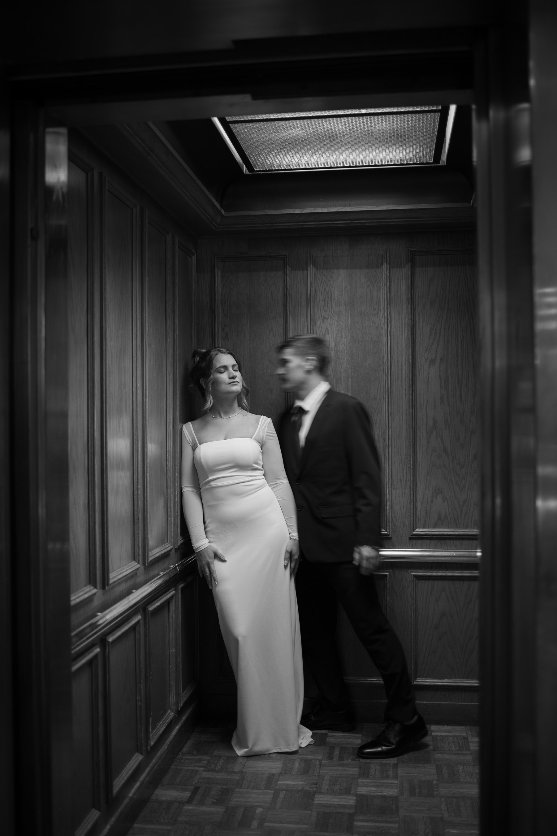 A bride and groom photographed in a classic elevator